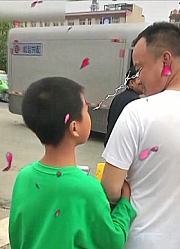 男孩走在路上玩手机，手却拉错人，有些人走着走着就捡了个儿子